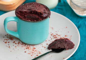 Quick Homemade Chocolate Microwave Mug Brownie Ready to Eat. Chocolate biscuit cake in a blue ceramic mug. Easy cooking concept, microwave baking. muffin chocolate. High quality photo