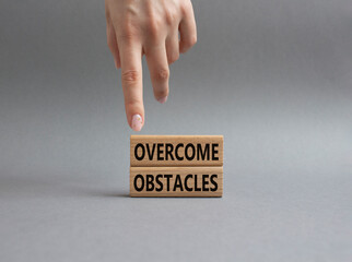 Overcome obstacles symbol. Concept words Overcome obstacles on wooden blocks. Businessman hand. Beautiful grey background. Business and Overcome obstacles concept. Copy space.