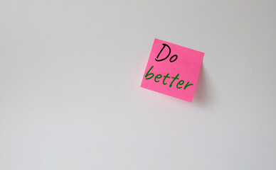 Do better symbol. Pink steaky note with concept words do better. Beautiful white background. Business and Do better concept. Copy space.