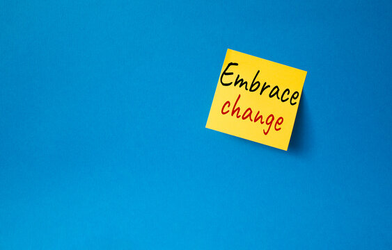 Embrace change symbol. Orange steaky note with concept words Embrace change. Beautiful blue background. Business and Embrace change concept. Copy space
