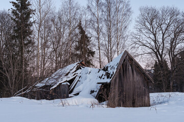 Fototapeta na wymiar A fallen barn by a field in Toten, Norway, in winter.