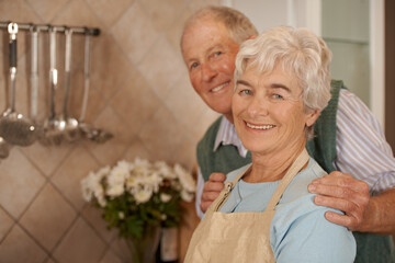 They still have dates. Portrait of an elderly couple standing together in the kitchen.