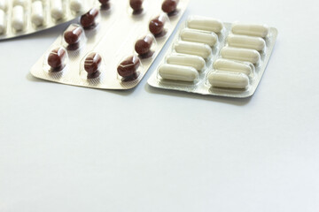 Vitamins and pills lie on a white background