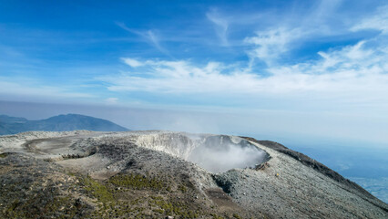 Seeing the inside of a volcano crater with smoke in east Java, Indonesia. Aerial view of volcano crater Mount Sindoro. 