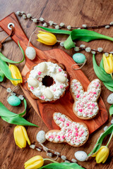 Easter cookies. easter bunnies with easter eggs and willow on wooden background