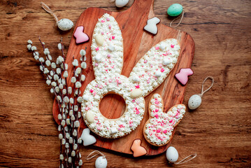 easter cake. easter bunny with easter eggs and willow on wooden background with copy space for your text