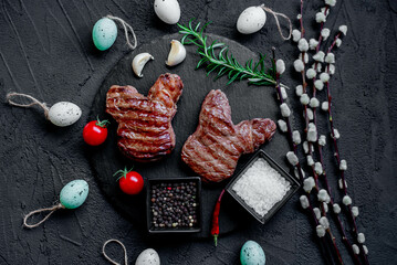 Easter grilled beef steaks in the shape of a rabbit on a stone background