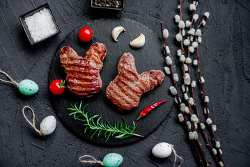 Easter grilled beef steaks in the shape of a rabbit on a stone background