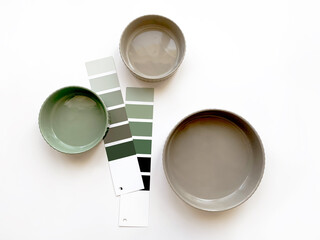 Modern minimal plates with neutral green and beige color swatches on white background, top view....