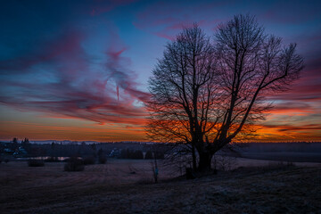 Fototapeta na wymiar Winter sunset with color sky near Andelska Hora village with ruins and chapel