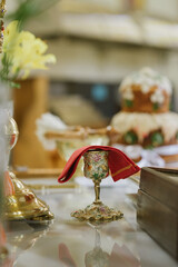 Holy communion in golden cup on table on church.Taking holy Communion.Cup of glass with red wine.