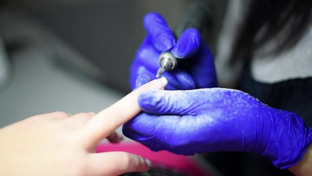 Professional manicure master files nails , preparation for polishing with shellac manicure , close up 4k footage 