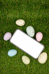 Phone with blank empty screen on background of easter eggs with  in  on green grass. Space for text. Happy Easter! Smartphone mockup, top view