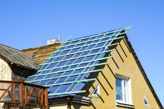 New roofing film and wood lathing before replacing the roof covering of a residential house