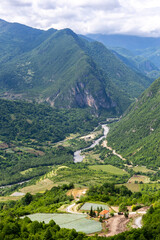Tskhenistsqali river valley landscape in Racha region of Georgia with Svaneti mountain range, lush green forests and vineyards seen from to Khvamli Mountain.