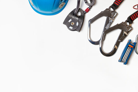 Helmet for work at height or mountaineering. Equipment for mountaineering and high-altitude works. carabiners, pulleys, belts. Close-up. on a white background. Empty place.