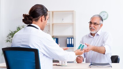 Old man visiting young male doctor