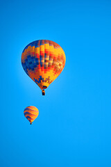 Flying hot air balloons against bright blue sky