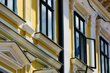 painted white wood windows. yellow stucco elevation. old classic architecture. decorative elements....