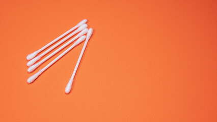 White sticks of cotton buds on a uniform table background. Pastel color. Close-up. Top view. Copy, empty space for text