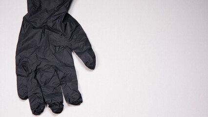 Black surgical medical gloves isolated on white background with hands. Rubber glove manufacturing, human hand is wearing a latex glove. Doctor or nurse putting on nitrile protective gloves