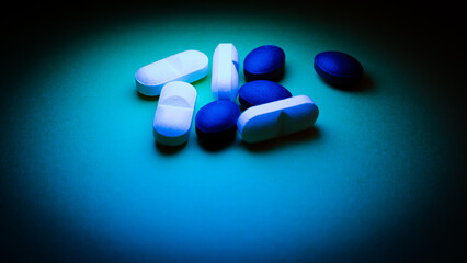 Pills on a blue background. Selective focus. Toned.