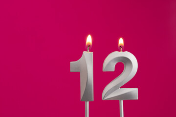 Number 12 - Silver Anniversary Candle on Rhodamine Red Background