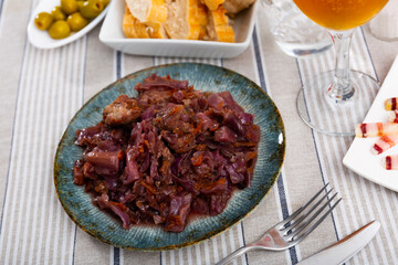 Delicious meaty oven baked pork ribs with side dish of braised red cabbage ..