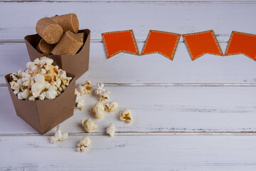 bowls of popcorn and peanut candy and paper flags on a white wooden table