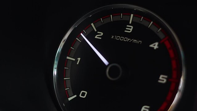 Car tachometer engine revving needle indicates redline speed vibration 