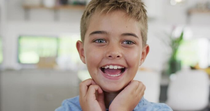 Portrait of happy caucasian boy looking at camera and smiling, slow motion