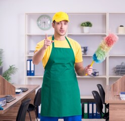 Young male contractor cleaning the office