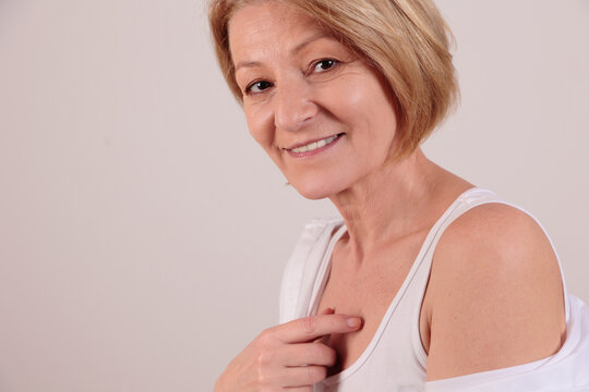 Happy smiling mature woman looking at camera portrait. Skin and body care concept.