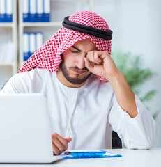 Arab businessman working in the office doing paperwork with a pi
