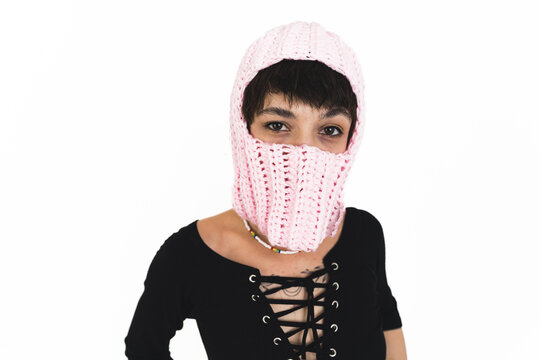 Close shot. Woman wearing pink balaclava and black laced top. White background. High quality photo