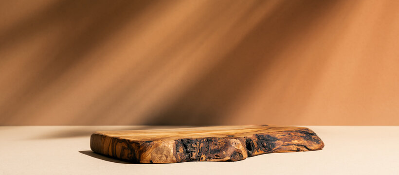 Wooden podium for cosmetic products, perfumes or food against brown background. Front view.	