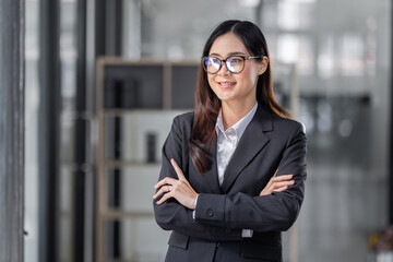 Portrait of cheerful young Asian business woman holding document folder and gets brilliant idea in mind office background