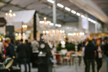 Defocused view of people visiting a fair - silhouette ob business persons talking communication and discovering new opportunities and corporations
