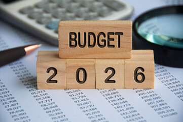 Budget 2026 text on wooden blocks with data analysis and office concept background. Budgeting...