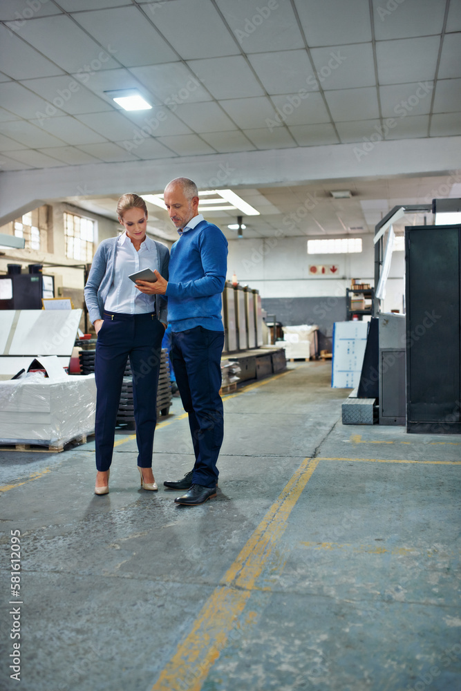 Aufkleber catching up on the factory progress. two colleagues working together in a printing factory.