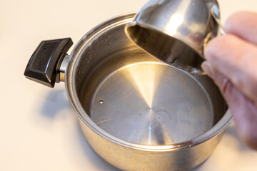 計量した水を鍋に入れる