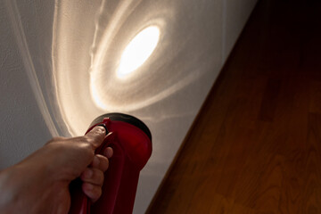 暗い廊下の壁を照らす懐中電灯