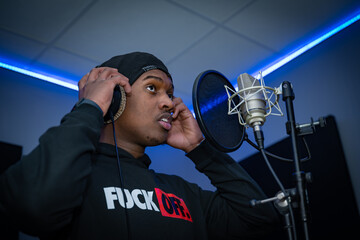Jeune rappeur en enregistrement devant un micro
