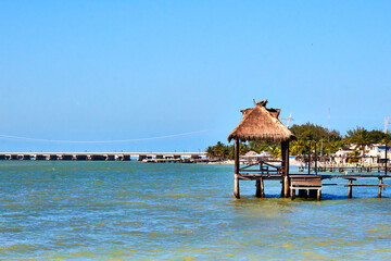 pier with bungalow and lampposts, sea in the background, isla aguada campeche 
