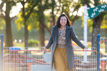 A happy, empowered woman wearing a jacket during golden hour sunset. 