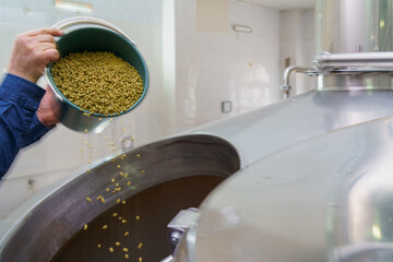 The process of adding malt to a vat at a brewery, motion blur, steam from brewing beer. Background