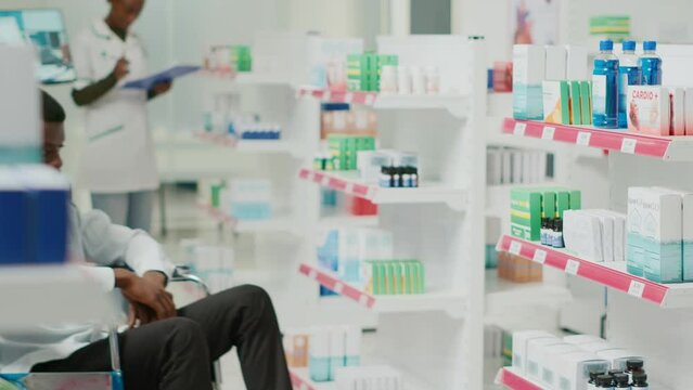 Pharmacy assistant helping woman with impairment, talking to cient and social worker in pharmaceutical shop. Female specialist giving pills and vitamins to customers, health center.
