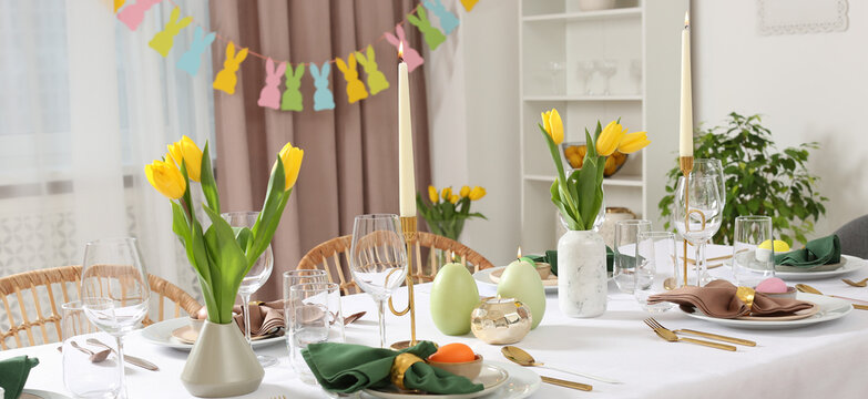 Festive Easter table setting with yellow tulips indoors, banner design