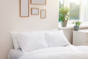 Fototapeta premium White soft pillows on cozy bed in room