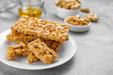 Delicious peanut kozinaki bars on light gray textured table, closeup. Space for text